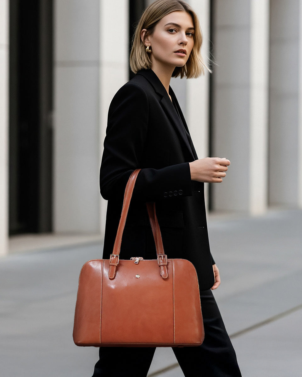 Woman holding a brown leather briefcase in an urban setting