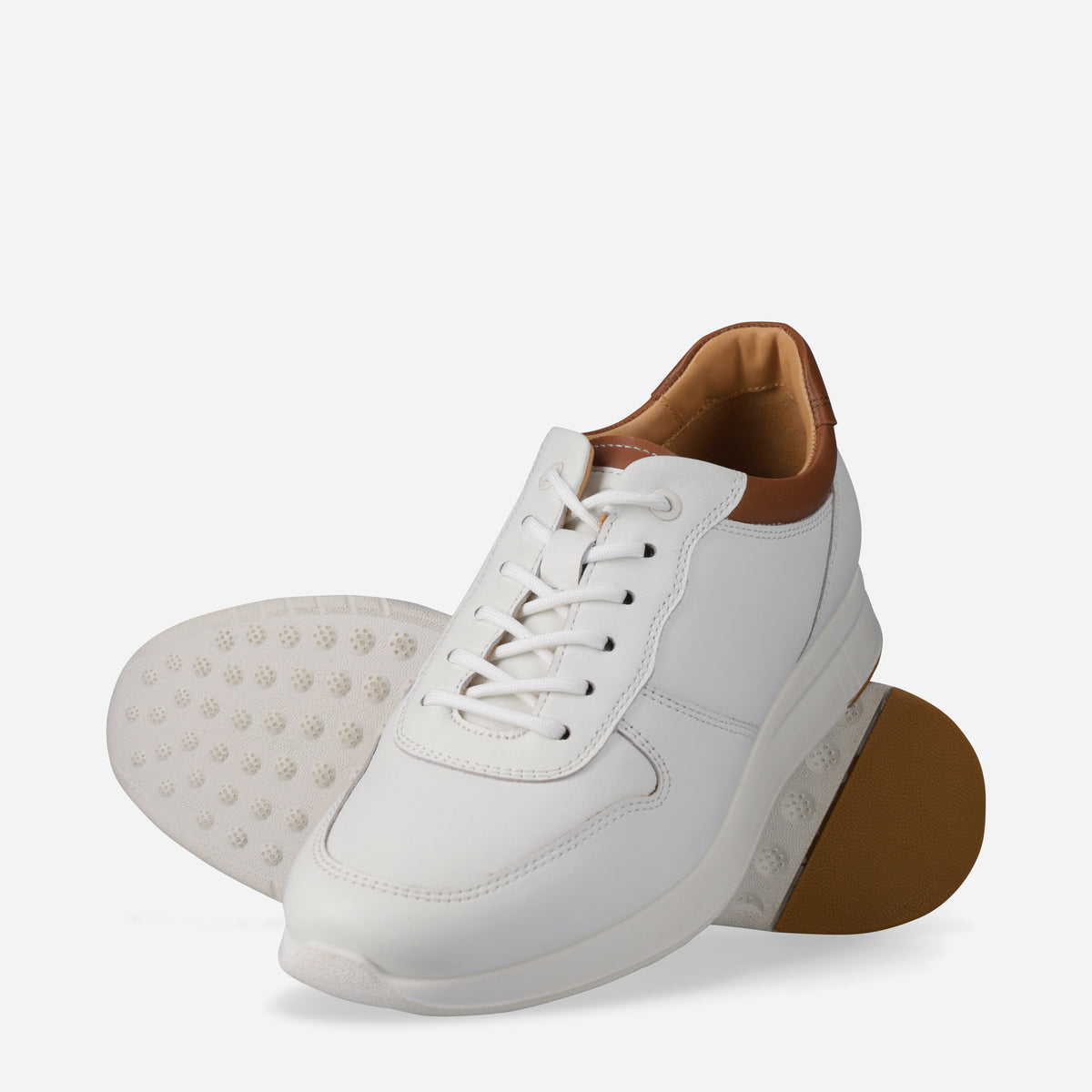 Pair of white Franca Sneakers, one showing the white and tan sole
