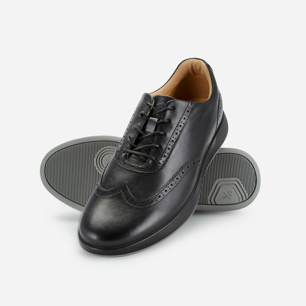 Black leather wingtip brogue sneakers showing the grey rubber tread, Jekyll & Hide