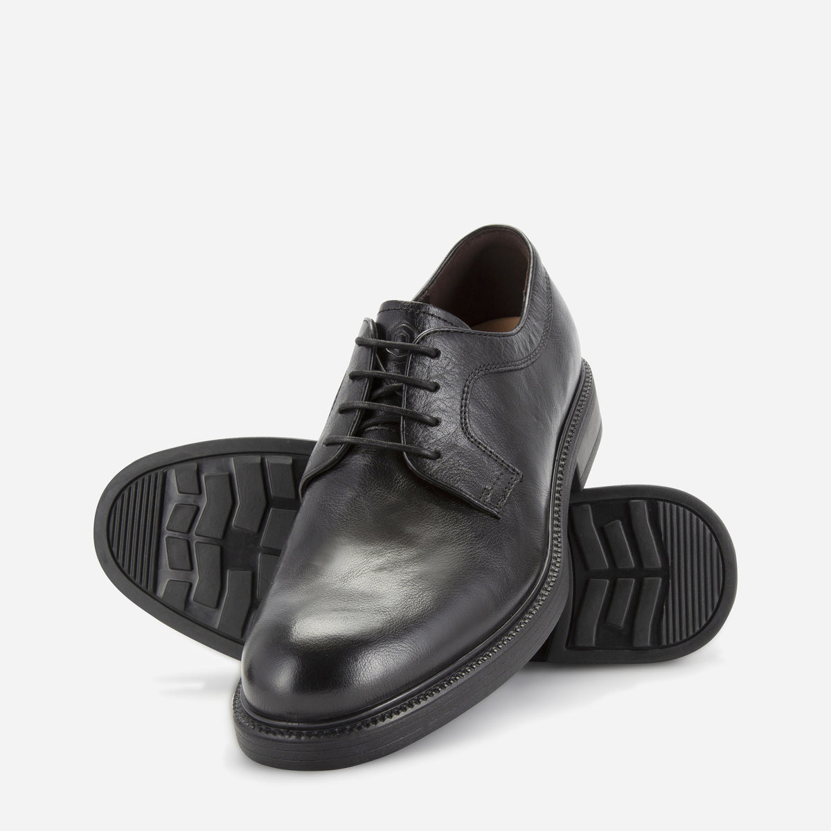 Pair of black Oxford Derby Shoes, one showing the lug rubber sole