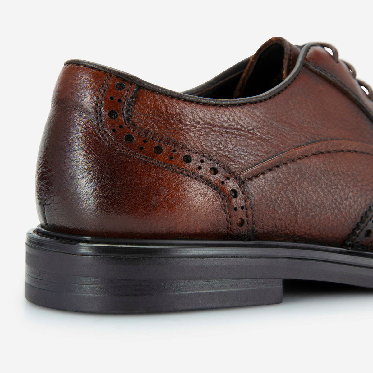 Close-up of the laser-cut brogue detailing on brown tumbled leather, Jekyll & Hide