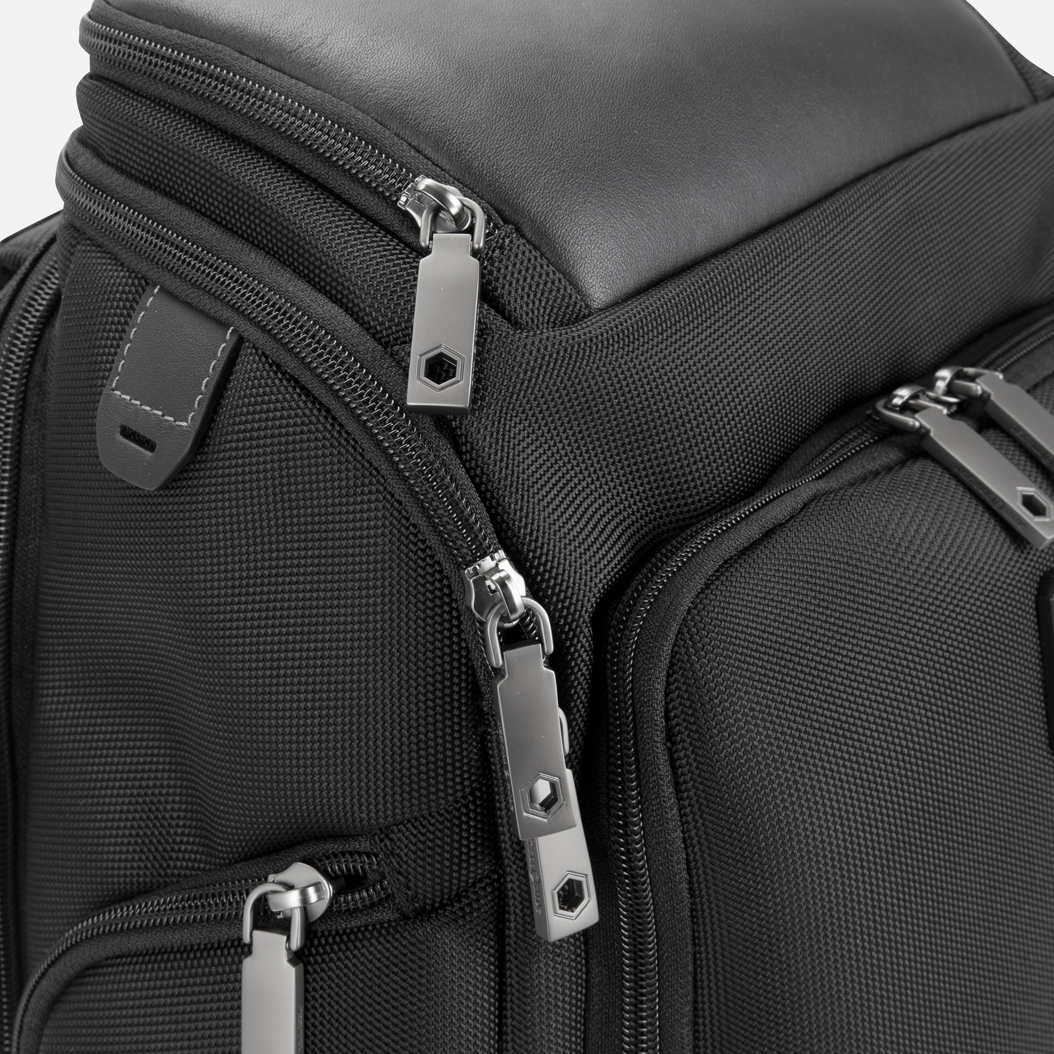 Jekyll & Hide Tokyo Flip-Top Backpack in Black, close-up of the engraved gunmetal zip pullers and leather tabs