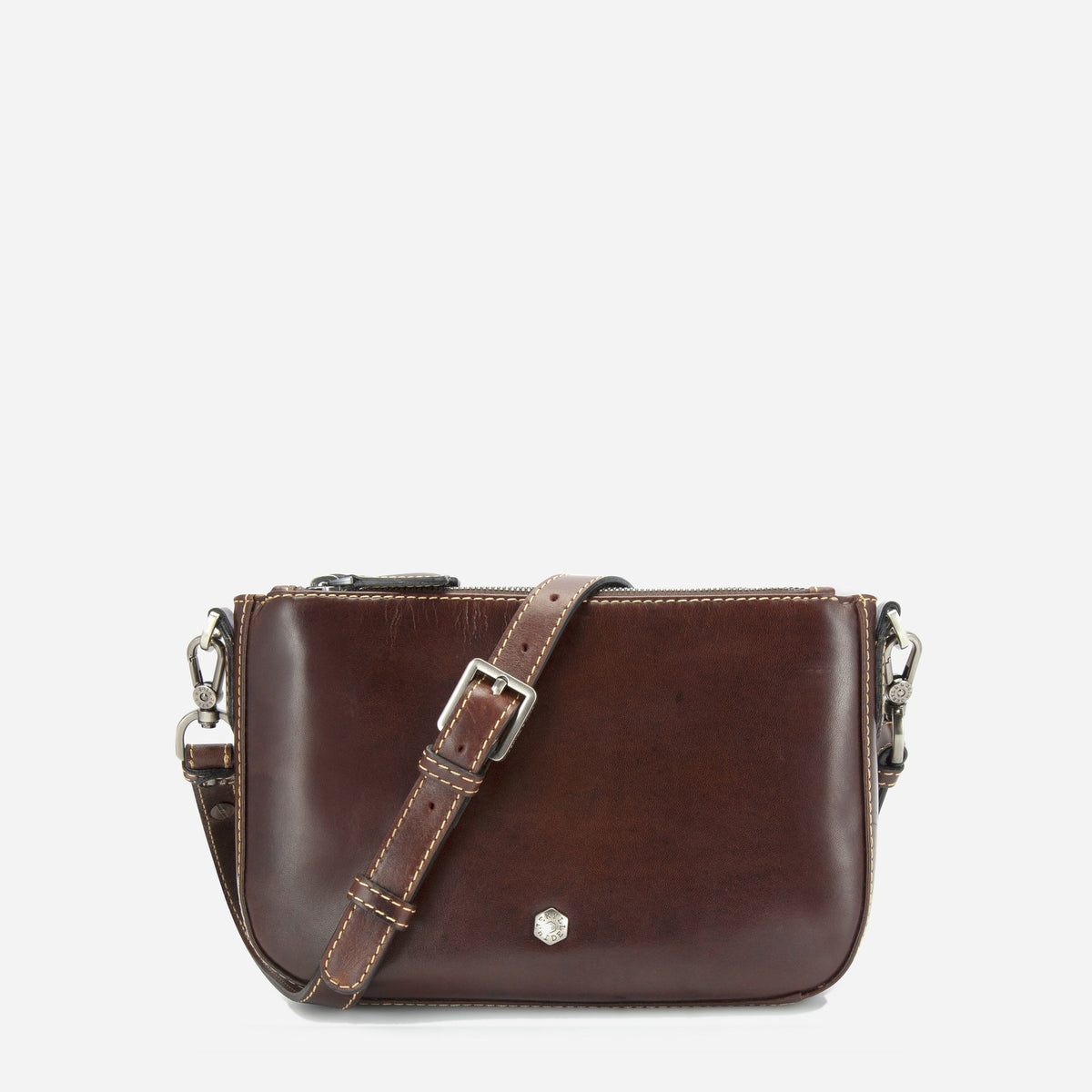 A dark brown leather crossbody bag with a matching adjustable shoulder strap, silver-tone hardware, and a small hexagonal metal emblem on the front, shown against a plain light gray background.