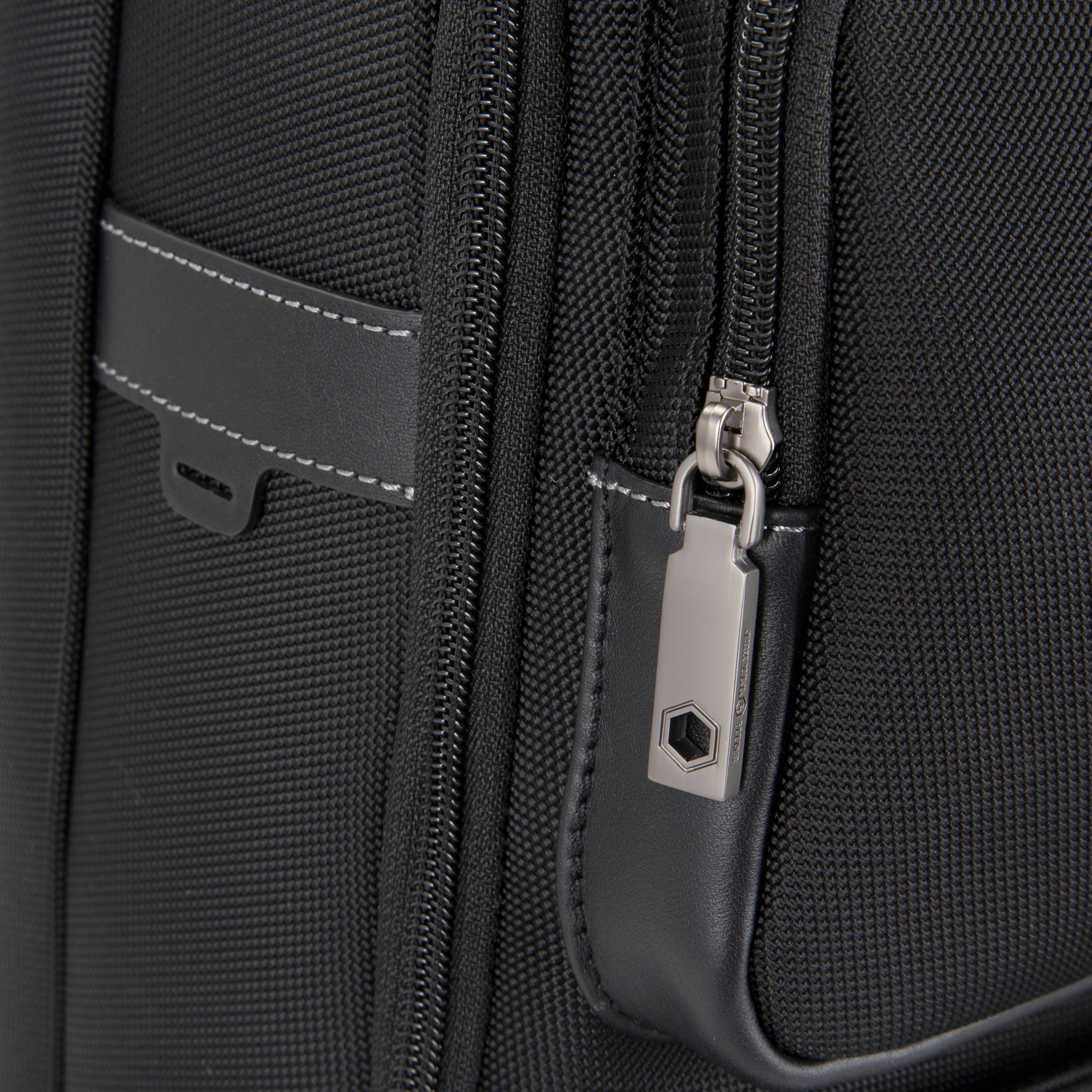 Jekyll & Hide Tokyo Square Backpack in Black, close-up of the engraved gunmetal zip puller and leather trim