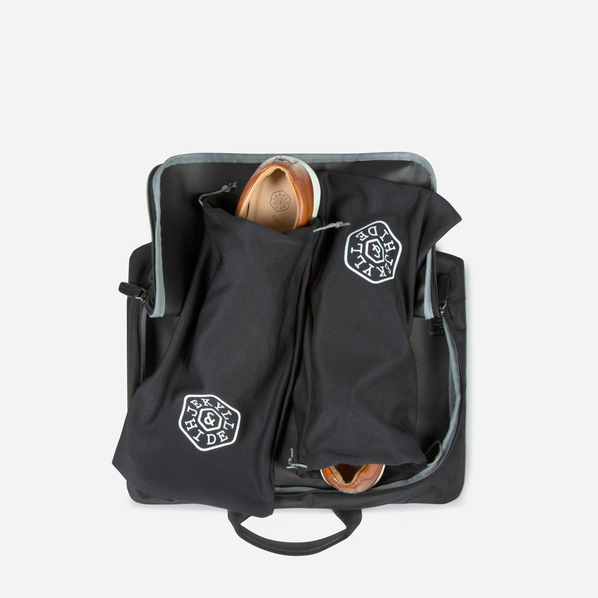 Black shirt and laundry bag open, with the waterproof shoe bags inside, Jekyll & Hide