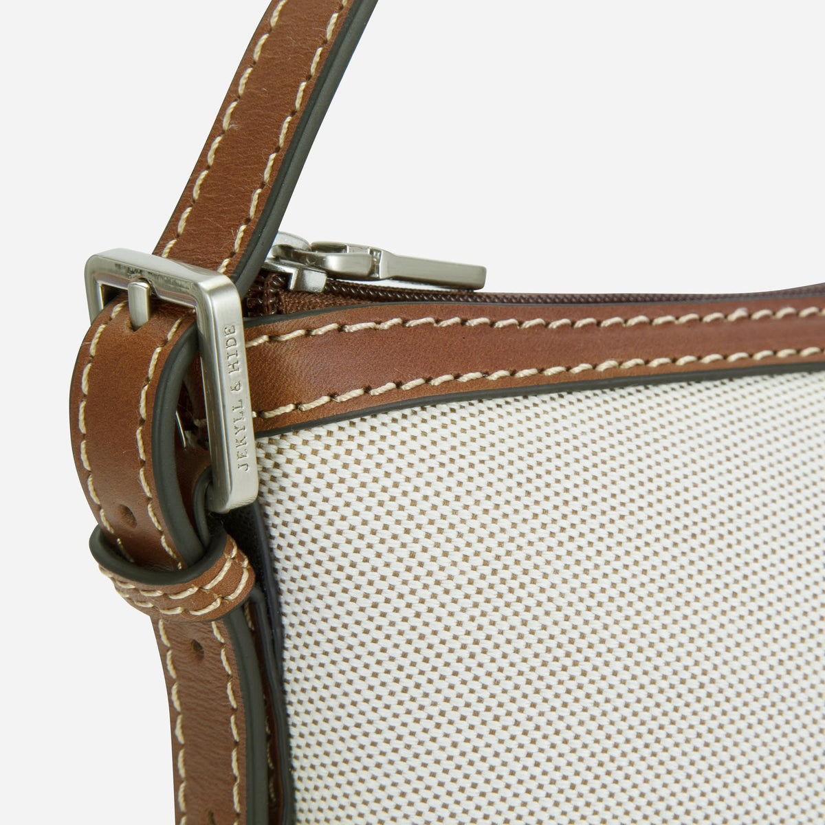 Close-up of the Canvas Shoulder Bag's buckled Colt leather strap and contrast stitching