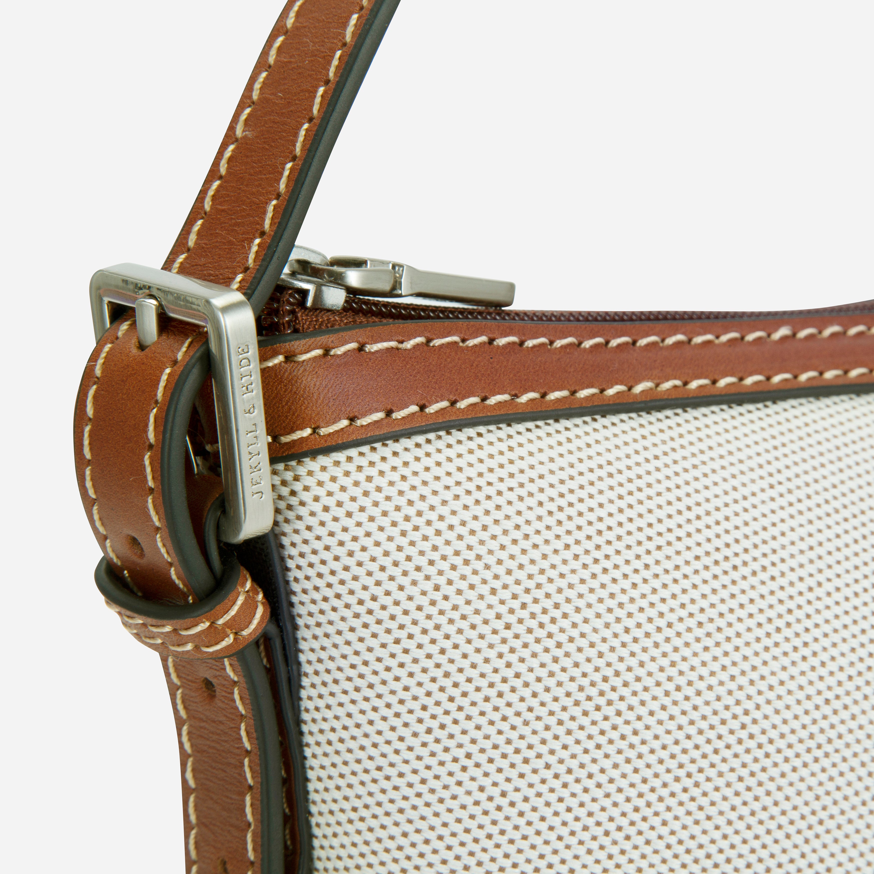 Jekyll & Hide Canvas Sling Handbag in Colt, close-up of the engraved strap buckle and saddle stitching